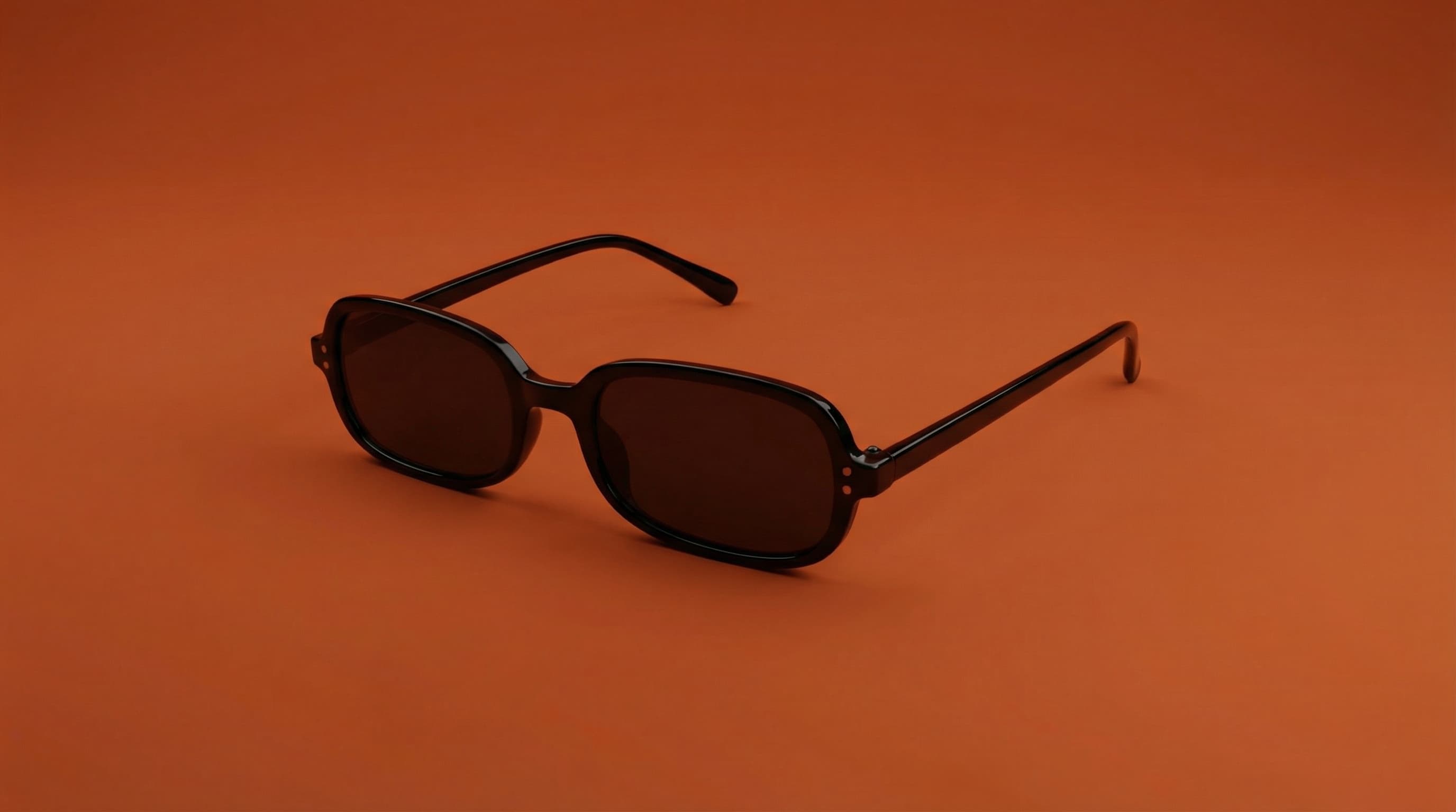 Background: Solid, saturated burnt-orange backdrop with a smooth, studio-finished surface. No visible seams or gradients beyond intentional light falloff.