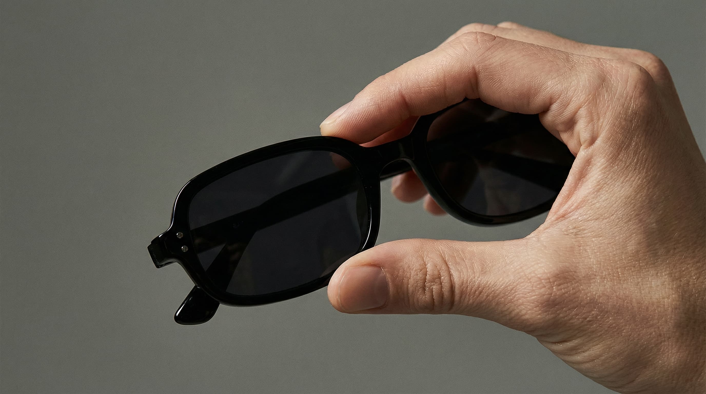 hand holding glasses close-up of just the hand