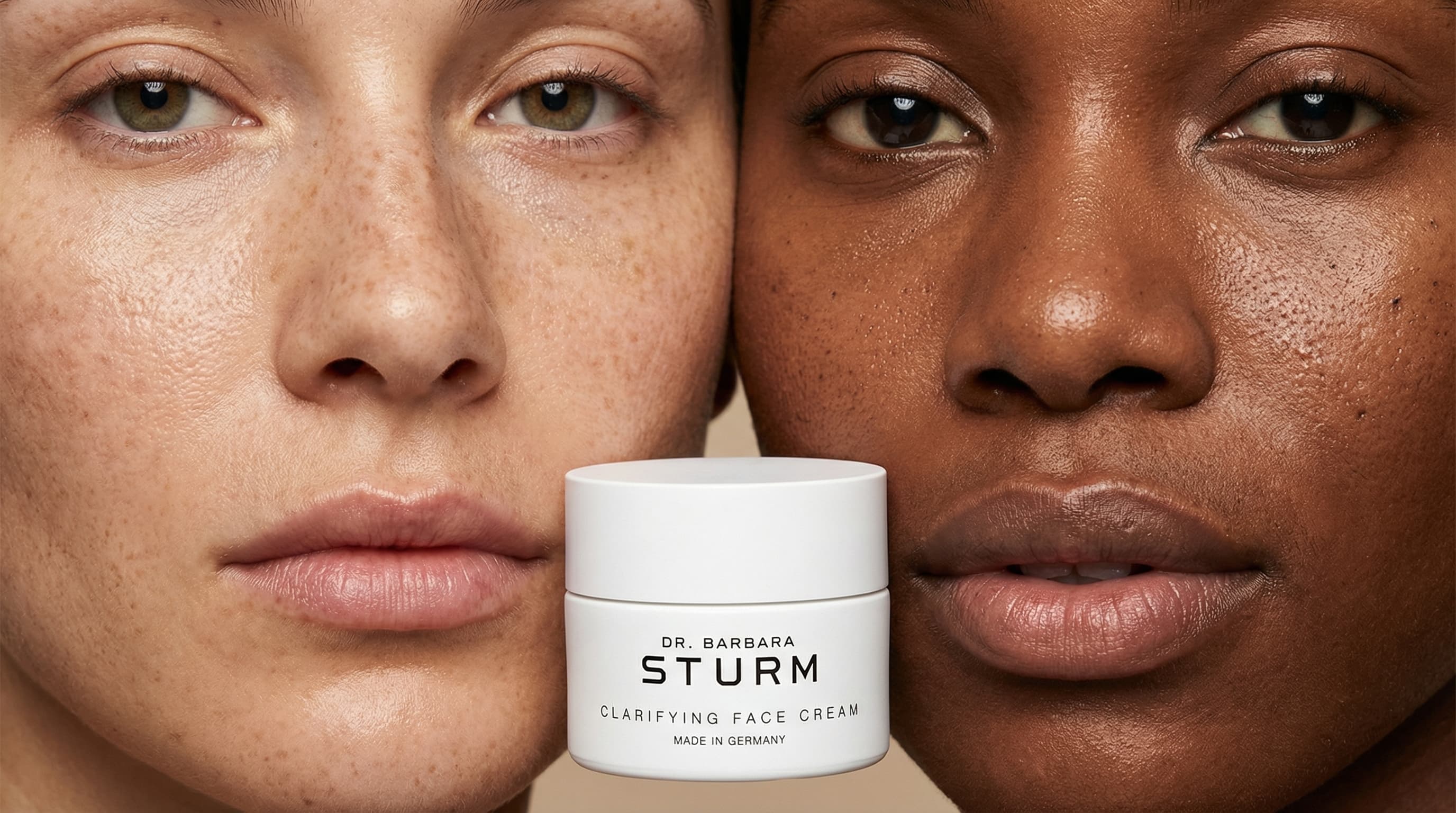 The photo is a bold, intimate beauty editorial focused on skin, texture, and contrast.
Two faces are framed extremely close to the camera, cropped so that only portions of each face are visible. Between them, a small skincare jar is held at mouth level, becoming the central anchor of the composition. The proximity creates a sense of tension and connection, drawing attention to skin detail and expression.
Both faces are shown with minimal makeup and visible, natural skin texture—freckles, pores, and subtle shine are intentionally preserved. One subject’s lips are softly closed, the other slightly parted in a relaxed, expressive gesture, adding a human, emotional quality to the image.
Lighting is soft and even, minimizing shadows and emphasizing skin tones and surface detail. The background is clean and neutral, allowing skin and product to dominate the frame without distraction.
The composition feels deliberate and graphic, using symmetry, closeness, and contrast in skin tones to communicate inclusivity, authenticity, and confidence.
Overall, the image feels modern, intimate, and editorial, prioritizing real skin, diversity, and presence over polish or traditional beauty idealization.