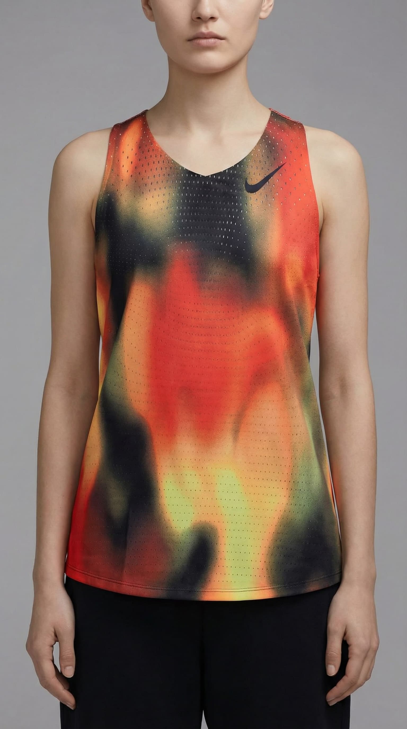 The image is a clean, minimalist fashion portrait with a strong product-first focus.
A model stands in a relaxed, neutral pose, framed from mid-torso up against a smooth gray studio background. The composition is simple and uncluttered, directing full attention to the garment rather than action or environment.
The T-shirt’s gradient print—shifting from white into warm yellow and red—becomes the visual anchor. Its soft fade feels controlled and graphic, almost like a color field, giving the piece a modern, design-led presence. Branding is subtle and restrained, reinforcing a premium, understated tone.
Lighting is even and soft, with minimal shadowing. This keeps fabric texture, fit, and color clarity accurate and readable, typical of high-end lookbook or campaign imagery.
Overall, the image feels modern, calm, and design-forward, sitting at the intersection of performancewear and contemporary fashion. It prioritizes clarity, material quality, and visual balance over storytelling or lifestyle context.