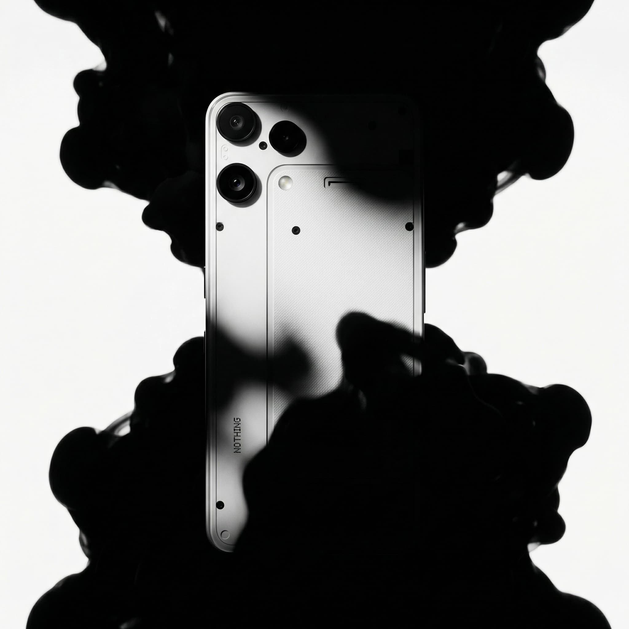 The image is a dramatic, conceptual product portrait built around contrast and symbolism.
A game controller appears centered and partially engulfed by deep black shadow forms above and below, creating a mirrored, almost inkblot-like composition. The stark white background heightens the contrast, making the controller’s silhouette and controls feel sharp, graphic, and iconic.
Lighting is high-contrast and directional, carving out the controller’s shape while allowing portions to fall into darkness. This selective illumination gives the object a sense of tension and power rather than neutrality or friendliness.
The composition feels abstract and deliberate—less about showing every detail and more about evoking presence, intensity, and immersion. The shadows feel almost organic, as if the controller is emerging from or being consumed by something unseen.
Overall, the image feels bold, cinematic, and conceptual, positioning the object as a cultural symbol rather than a simple piece of hardware. It leans into mood and visual impact over clarity or usability, typical of high-end brand or campaign imagery rather than retail.